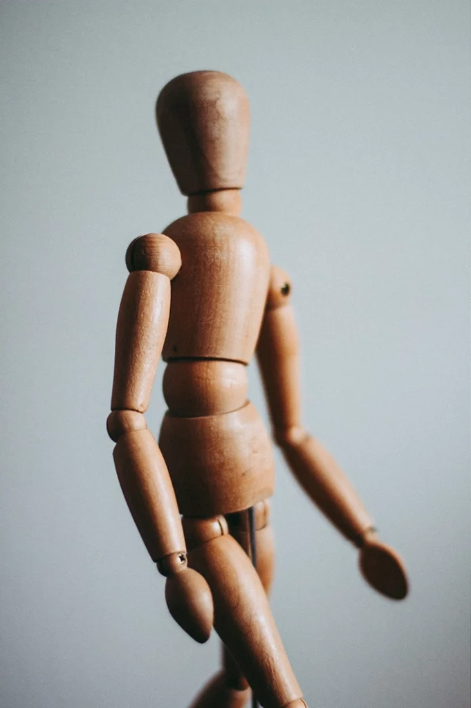 Photo d'une marionnette en bois représentant l'équilibre du corps pour la posturologie